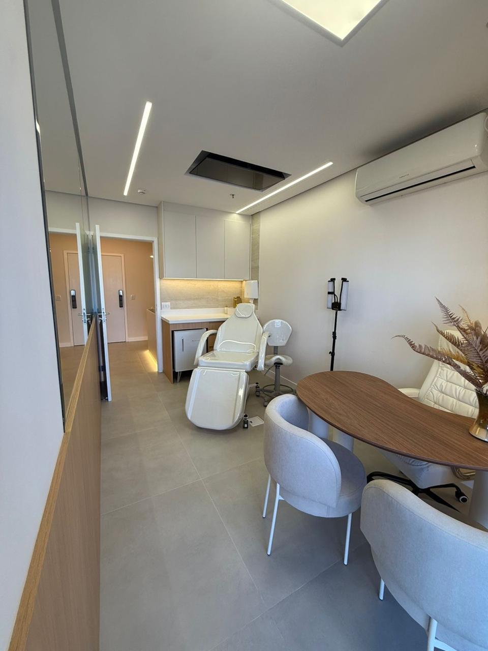 Sala de atendimento com maca reclinável e espaço de trabalho